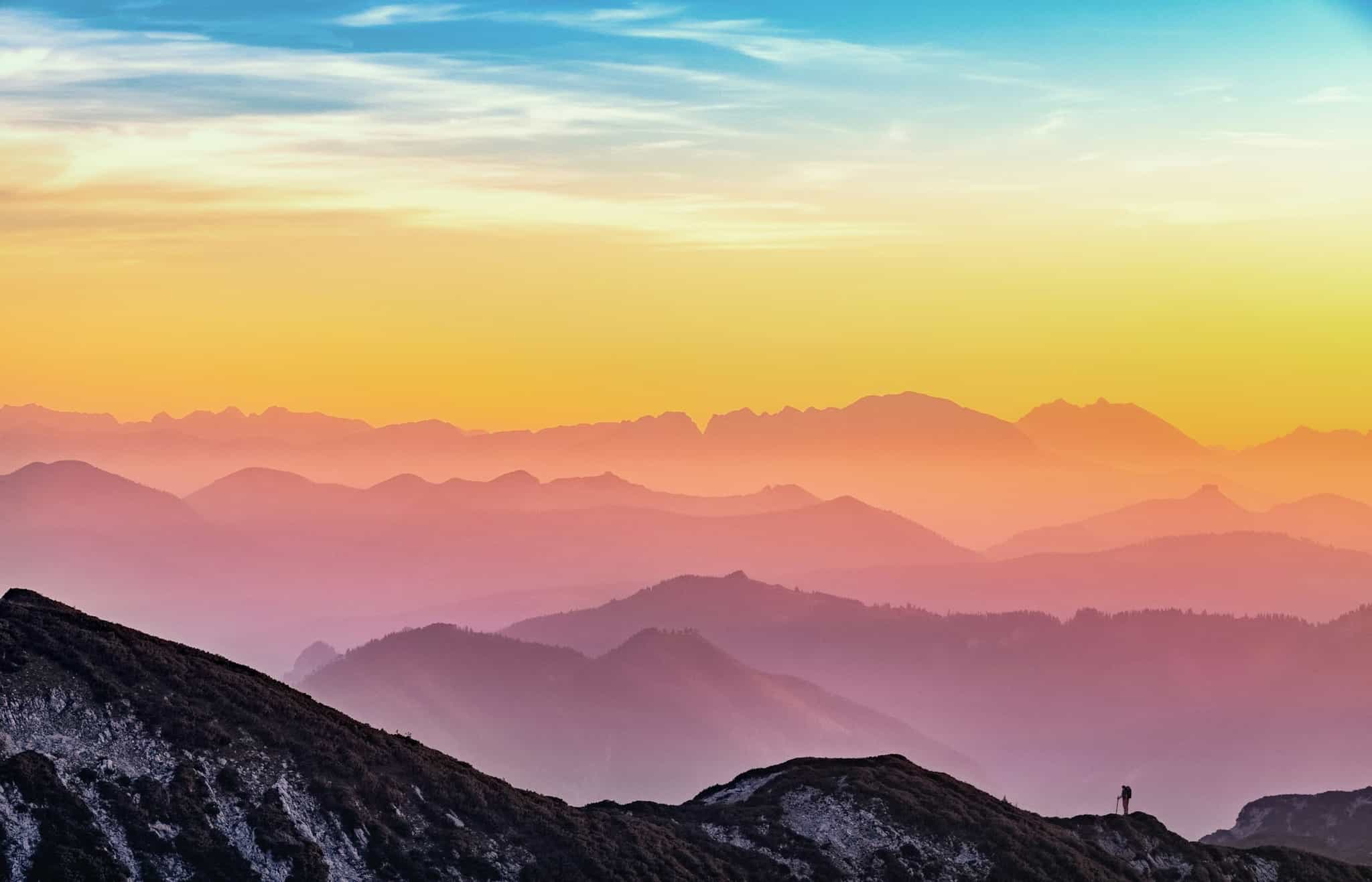 Sanfte Bergketten in warmen Pastelltönen bei Sonnenuntergang